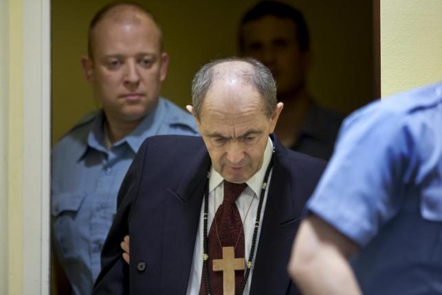 Bosnijos serbų generolas Zdravko Tolimir įvedamas į teismo salę Hagoje. Šaltinis: Reuters
